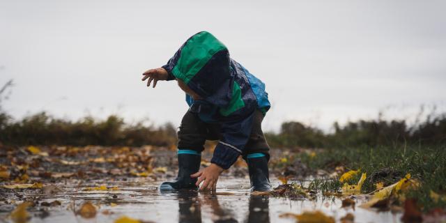 enfant joue dans une flaque de pluie