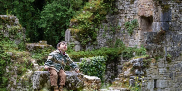 Les vestiges du Moulin de Tournefeuille sur le circuit du Moulin du Saut. Un enfant est assis au coeur des ruines